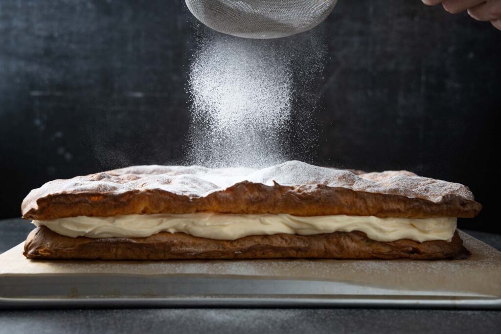 dusting the karpatka with confectioners' sugar